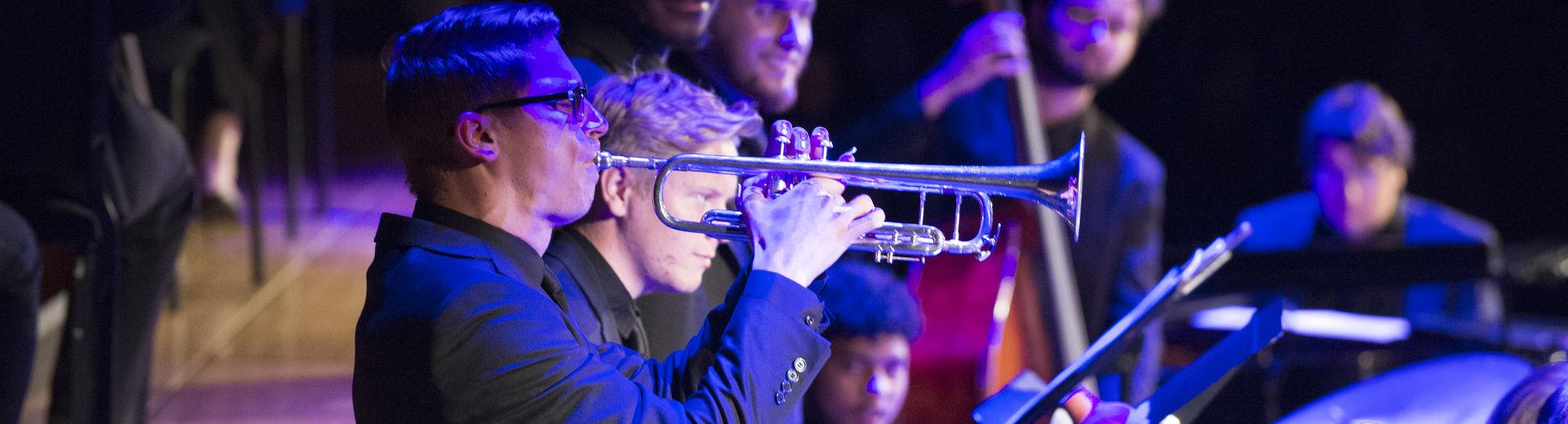 Student playing the trumpet at a live performance. 