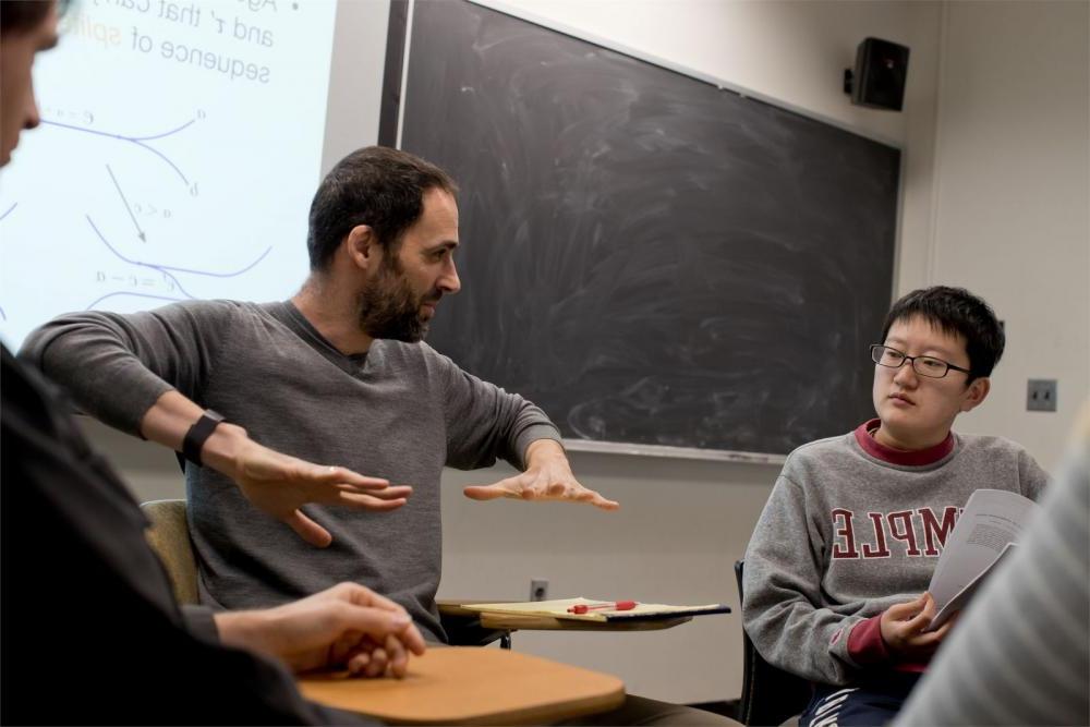 A Temple math professor is talking to his students in a classroom.