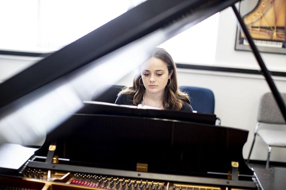 A Boyer College of Music and Dance student plays the piano in a rehearsal room on Temple's campus.