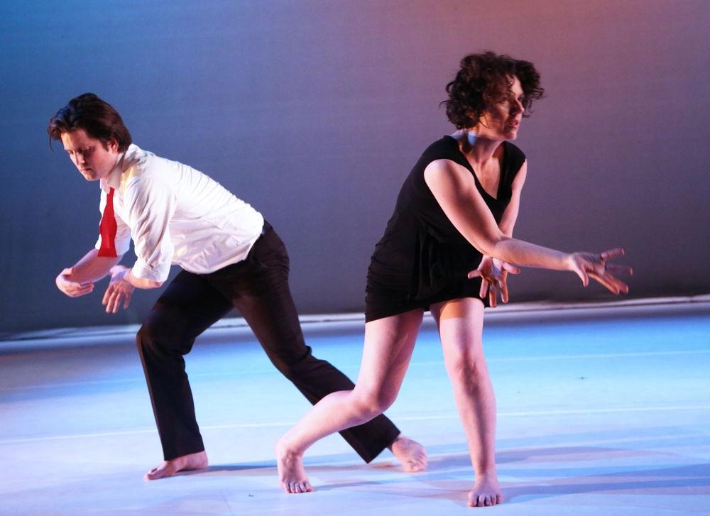 Two dancers perform on stage.